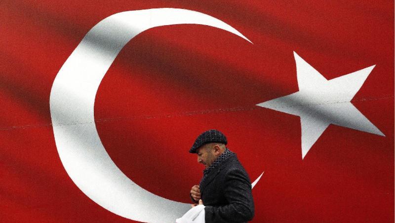 Ein Mann geht an einer türkischen Flagge vorbei. Ein Mann geht an einer türkischen Flagge vorbei.