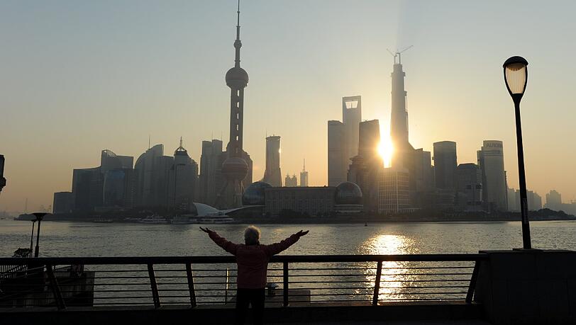Eine Bewohnerin von Shanghai macht in Sichtweite der Wolkenkratzer von Shanghai-Pudong Frühsport. Eine Bewohnerin von Shanghai macht in Sichtweite der Wolkenkratzer von Shanghai-Pudong Frühsport.