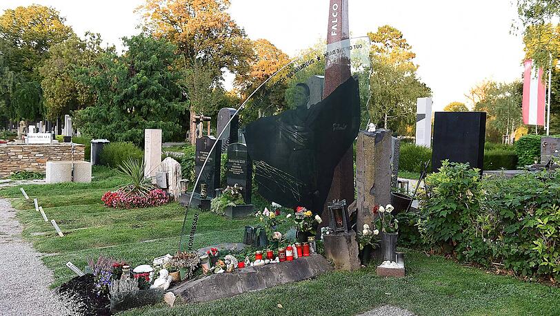 Falcos Grabstätte besteht aus drei zentralen Komponenten: eine Glasplatte (symbolisiert sein Werk), ein Obelisk (steht für den Künstler) und eine Säule (symbolisiert die Privatperson). Falcos Grabstätte besteht aus drei zentralen Komponenten: eine Glasplatte (symbolisiert sein Werk), ein Obelisk (steht für den Künstler) und eine Säule (symbolisiert die Privatperson).