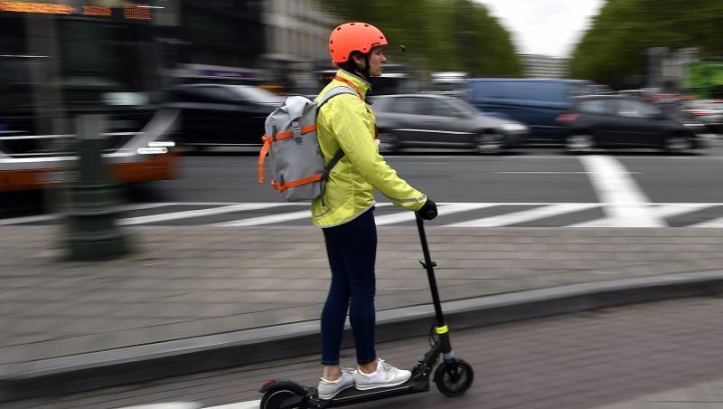 Ein Frau fährt auf einem E-Tretroller auf einem Fahrradweg. Ein Frau fährt auf einem E-Tretroller auf einem Fahrradweg.