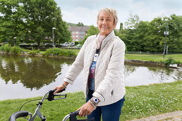 Diese Seniorin geht mit der Mobilversion eines Hausnotrufs spazieren. Diese Seniorin geht mit der Mobilversion eines Hausnotrufs spazieren.