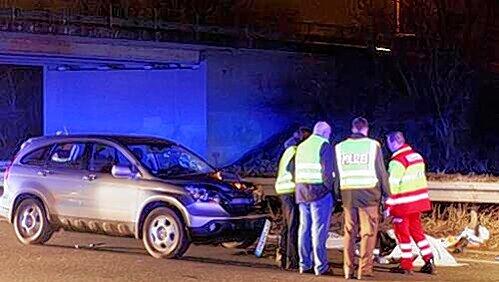Die Windschutzscheibe des Hondas ist zertrümmert, Helfer stehen um die abgedeckte Leiche am Rand der B4 herum. Die Windschutzscheibe des Hondas ist zertrümmert, Helfer stehen um die abgedeckte Leiche am Rand der B4 herum.