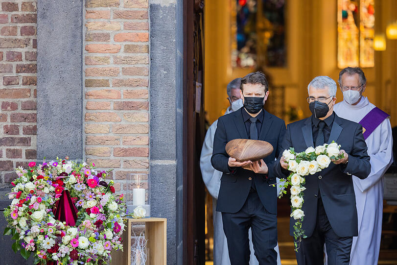 Bestatter tragen die herzförmige Urne nach der Trauerfeier aus der Kirche St. Martin