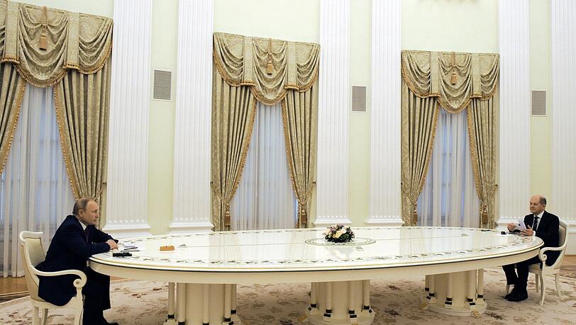 Russlands Präsident Wladimir Putin (links) und Bundeskanzler Olaf Scholz (SPD) sitzen sich an einem langen Tisch im Kreml gegenüber. Russlands Präsident Wladimir Putin (links) und Bundeskanzler Olaf Scholz (SPD) sitzen sich an einem langen Tisch im Kreml gegenüber.