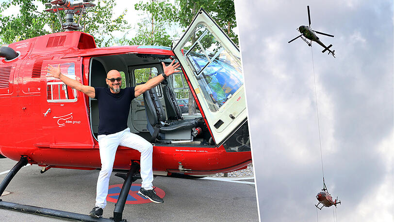 Der Unternehmer Jochen Schweizer posiert vor dem Bölkow BO 105, der von einem anderen Helikopter nach Taufkirchen transportiert wurde.