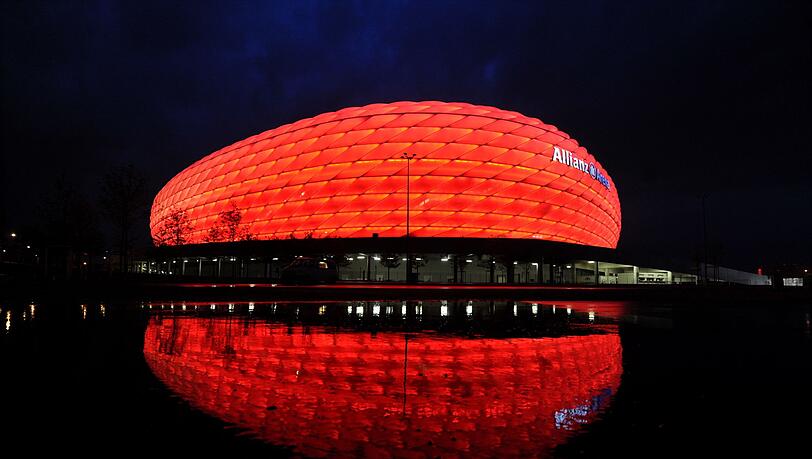 Wolken ziehen über die beleuchtete Allianz Arena. Wolken ziehen über die beleuchtete Allianz Arena.