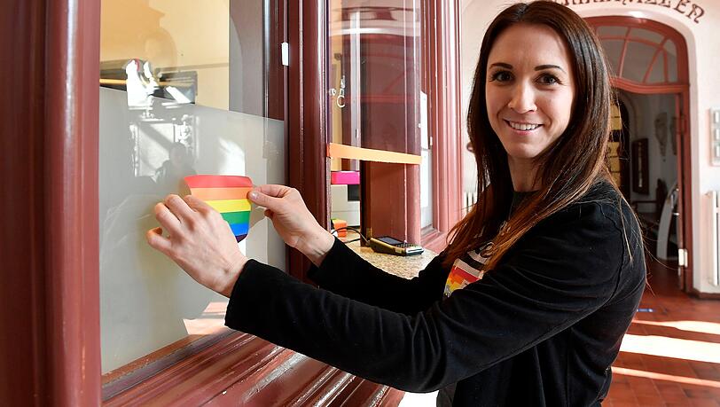 Eine Mitarbeiterin des Müller'schen Volksbads bringt einen Regenbogen-Aufkleber an. Eine Mitarbeiterin des Müller'schen Volksbads bringt einen Regenbogen-Aufkleber an.