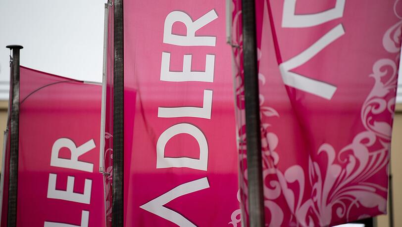 Fahnen mit dem Logo des Unternehmens "Adler Modemärkte" wehen vor einem Einkaufszentrum. Fahnen mit dem Logo des Unternehmens "Adler Modemärkte" wehen vor einem Einkaufszentrum.