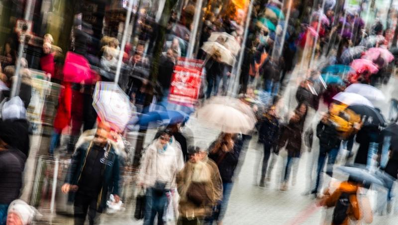 Passanten mit Einkaufstüten gehen durch eine Fußgängerzone. Passanten mit Einkaufstüten gehen durch eine Fußgängerzone.