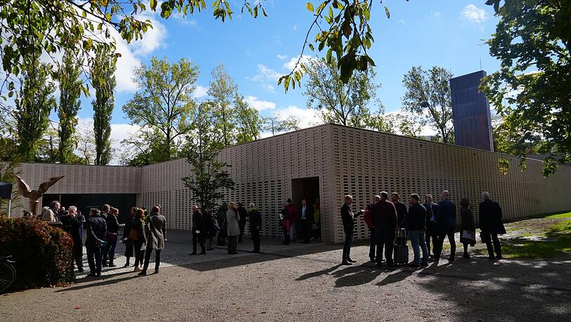 Das neue Krematorium, ein flaches, dreieckiges Gebäude, hat eine helle Sichtziegelfassade, die viele Lichteffekte ins Gebäude lässt.