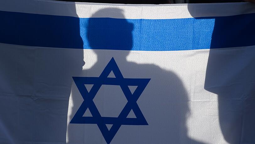 Teilnehmer einer Solidaritätskundgebung in Magdeburg schwenken eine Israel-Flagge. Teilnehmer einer Solidaritätskundgebung in Magdeburg schwenken eine Israel-Flagge.