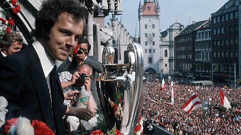 Klar, auch der Rathausbalkon spielt eine große Rolle in der Historie des FC Bayern. In über 125 Jahren wurden hier schon einige Trophäen in die Luft gehalten – und Tausende Fans feierten dabei vor dem Rathausbalkon. Wie hier, als Franz Beckenbauer den Sieg des Europapokals der Landesmeister 1974/75 feiert und das Herz der Stadt voll war mit Anhängern des Vereins. Klar, auch der Rathausbalkon spielt eine große Rolle in der Historie des FC Bayern. In über 125 Jahren wurden hier schon einige Trophäen in die Luft gehalten – und Tausende Fans feierten dabei vor dem Rathausbalkon. Wie hier, als Franz Beckenbauer den Sieg des Europapokals der Landesmeister 1974/75 feiert und das Herz der Stadt voll war mit Anhängern des Vereins.