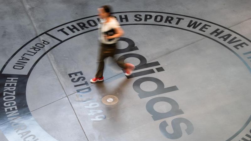 Ein großes Logo des Sportartikelherstellers "adidas" ist auf dem Boden eines Bürogebäudes zu sehen. Foto: Nicolas Armer/Archivbild Ein großes Logo des Sportartikelherstellers "adidas" ist auf dem Boden eines Bürogebäudes zu sehen. Foto: Nicolas Armer/Archivbild