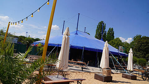 Die Aussichten sind sonnig: In der Half Moon Bar auf dem Tollwood macht man es sich auf Bierbänken oder mit einem Getränk in der Hand auf Liegestühlen im Sand gemütlich. Abends findet im Zelt die Silent Disco statt. Dort tanzen die Besucher zur Musik aus Kopfhörern. Das lädt auch zum Zuschauen ein. Die Aussichten sind sonnig: In der Half Moon Bar auf dem Tollwood macht man es sich auf Bierbänken oder mit einem Getränk in der Hand auf Liegestühlen im Sand gemütlich. Abends findet im Zelt die Silent Disco statt. Dort tanzen die Besucher zur Musik aus Kopfhörern. Das lädt auch zum Zuschauen ein.
