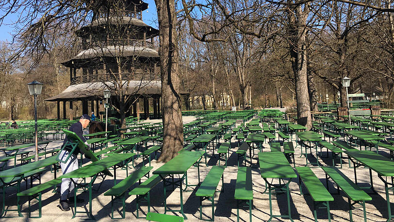 Der Biergarten am Chinesischen Turm ist vorerst geschlossen. Ein Arbeiter macht sich schon einmal an den grünen Bierbänken zu schaffen, die braucht es jetzt ja nicht mehr. Der Biergarten am Chinesischen Turm ist vorerst geschlossen. Ein Arbeiter macht sich schon einmal an den grünen Bierbänken zu schaffen, die braucht es jetzt ja nicht mehr.