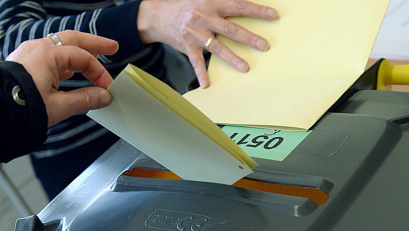Eine Frau wirft am 30.03.2014 in einem Wahllokal in München (Bayern) ihren Stimmzettel zur Stichwahl für den Posten des Münchner Obermeisters in die Wahlurne. Eine Frau wirft am 30.03.2014 in einem Wahllokal in München (Bayern) ihren Stimmzettel zur Stichwahl für den Posten des Münchner Obermeisters in die Wahlurne.