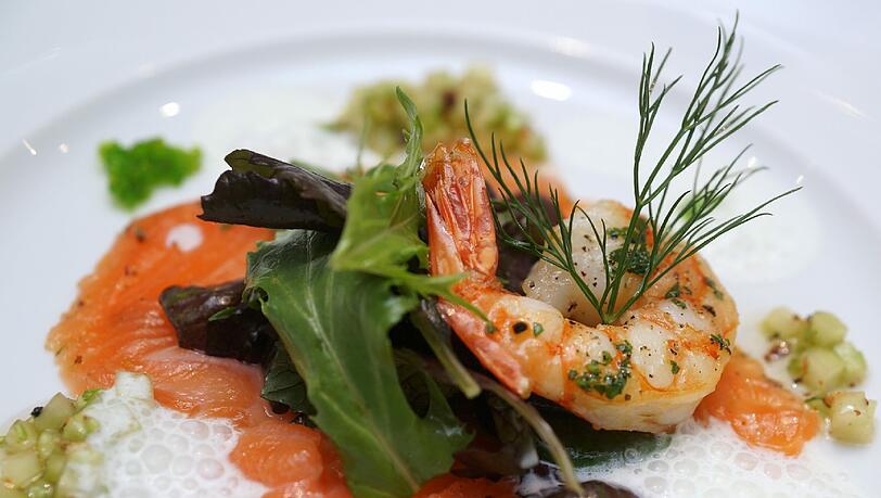 Gang 1: Gebratener Scampi und Carpaccio vom gebeizten Citruslachs mit Tobiko-Kaviar auf Wildkräutersalat und Gurkensalsa Gang 1: Gebratener Scampi und Carpaccio vom gebeizten Citruslachs mit Tobiko-Kaviar auf Wildkräutersalat und Gurkensalsa