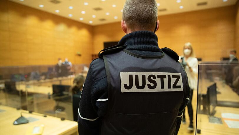 Ein Justizbeamter steht in einem Gerichtssaal. Ein Justizbeamter steht in einem Gerichtssaal.