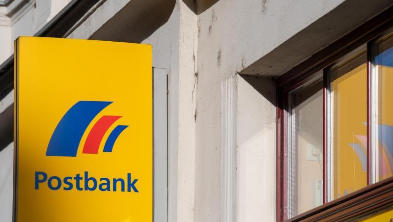 Ein Schild mit dem Logo der Postbank ist an der Fassade einer Bankfiliale angebracht. Foto: Monika Skolimowska/dpa-Zentralbild/dpa Ein Schild mit dem Logo der Postbank ist an der Fassade einer Bankfiliale angebracht. Foto: Monika Skolimowska/dpa-Zentralbild/dpa