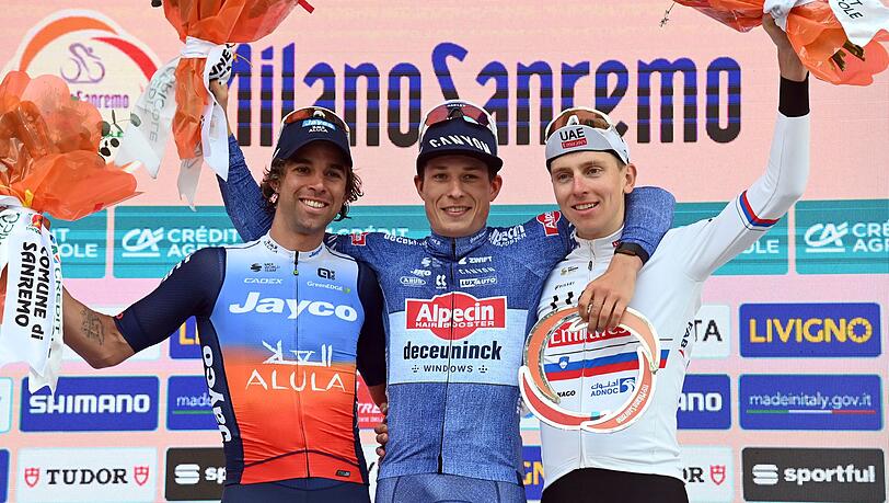 Der Belgier Jasper Philipsen (M) feiert mit dem zweitplatzierten Australier Michael Matthews (l) und dem drittplatzierten Slowenen Tadej Pogacar auf dem Podest. Der Belgier Jasper Philipsen (M) feiert mit dem zweitplatzierten Australier Michael Matthews (l) und dem drittplatzierten Slowenen Tadej Pogacar auf dem Podest.