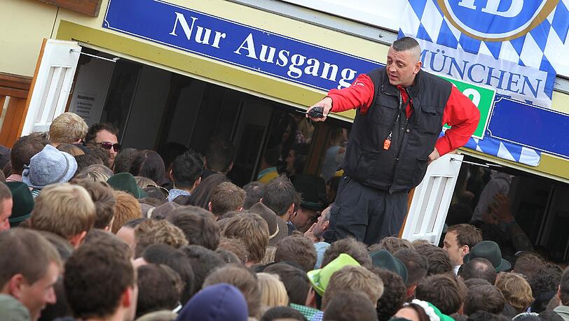 Ein Ordner kontrolliert den Ansturm auf ein Oktoberfest-Zelt. Ein Ordner kontrolliert den Ansturm auf ein Oktoberfest-Zelt.