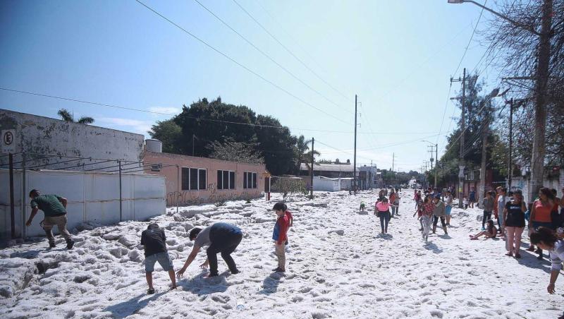Kinder begutachten die dicke Hagelschicht auf einer Straße in der Stadt Guadalajara. Kinder begutachten die dicke Hagelschicht auf einer Straße in der Stadt Guadalajara.