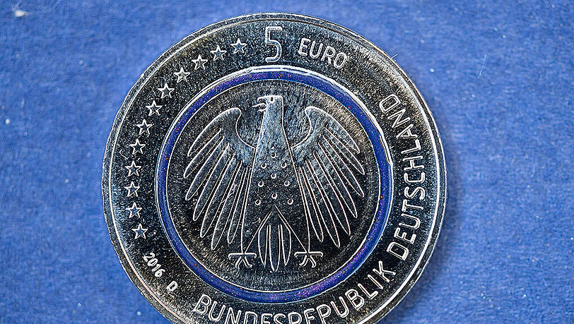 Die neue deutsche Fünf-Euro-Münze hat in der Mitte einen durchsichtigen, blau schimmernden Ring aus Kunststoff. Foto: Sven Hoppe Die neue deutsche Fünf-Euro-Münze hat in der Mitte einen durchsichtigen, blau schimmernden Ring aus Kunststoff. Foto: Sven Hoppe