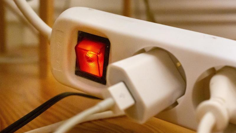Stecker sind in einem Wohnzimmer in eine Steckdosenleiste gesteckt. Stecker sind in einem Wohnzimmer in eine Steckdosenleiste gesteckt.