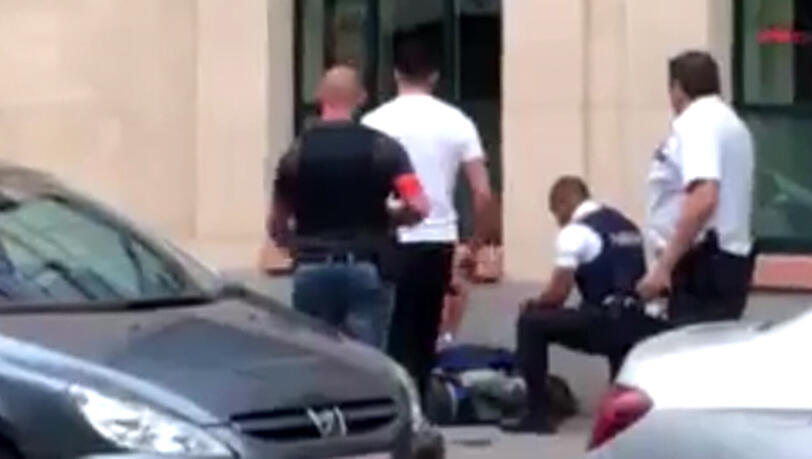Der angeschossene Täter am Boden - Polizisten nehmen ihn fest. Der angeschossene Täter am Boden - Polizisten nehmen ihn fest.