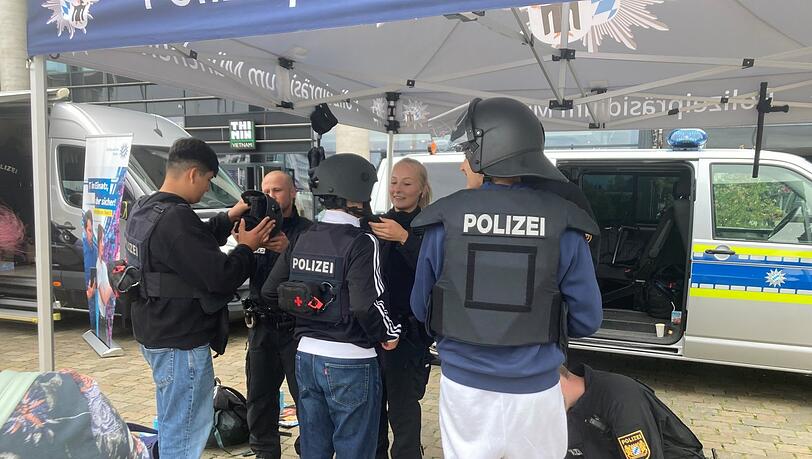 Eres, Marcel und Rubenprobierenneugierig die Schutzausrüstung der Münchner Polizei an, auch die Schusswesten. "Ganz schön schwer", finden sie. Eres, Marcel und Rubenprobierenneugierig die Schutzausrüstung der Münchner Polizei an, auch die Schusswesten. "Ganz schön schwer", finden sie.