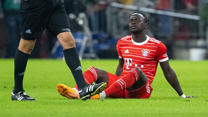 Sadio Mané sitzt auf dem Rasen. Sadio Mané sitzt auf dem Rasen.