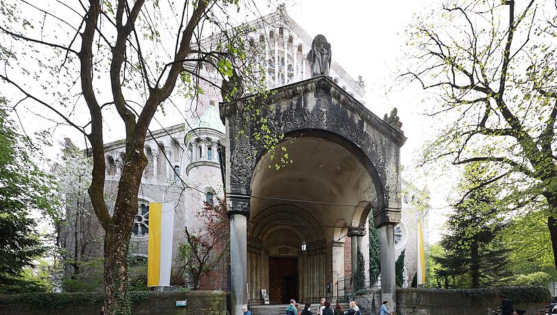 Ort der Stille: die muntere Gruppe der Viertelliebe-Führung vor der Kirche St. Maximilian von Pfarrer Rainer Maria Schießler.