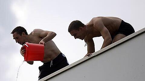 Franck Ribéry (l.) und Lukas Podolski kippen aus Jux Wasser über ihre Spieler-Kollegen.