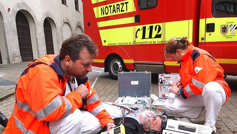 Sanitäter kümmern sich um einen Herzinfarkt-Patienten. Sanitäter kümmern sich um einen Herzinfarkt-Patienten.