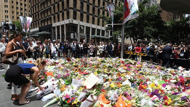Tausende Menschen legen in der Nähe des "Lindt"-Cafés Blumen nieder. Tausende Menschen legen in der Nähe des "Lindt"-Cafés Blumen nieder.
