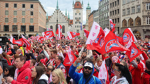 Die Fans des FC Bayern schwenken Fahnen und warten auf den Beginn der Meisterfeier am Marienplatz. Die Fans des FC Bayern schwenken Fahnen und warten auf den Beginn der Meisterfeier am Marienplatz.