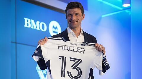 Stolz zeigt Thomas Müller bei einer Pressekonferenz in Vancouver sein Trikot, das ebenfalls seine legendäre Nummer 13 trägt. Stolz zeigt Thomas Müller bei einer Pressekonferenz in Vancouver sein Trikot, das ebenfalls seine legendäre Nummer 13 trägt.