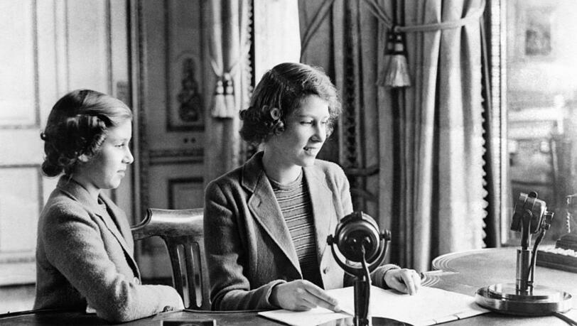 Die 14 Jahre alte Prinzessin Elizabeth (r.) und ihre Schwester Prinzessin Margaret nach der Ansprache während der Radiosendung "Children's Hour" auf Schloss Windsor. Die 14 Jahre alte Prinzessin Elizabeth (r.) und ihre Schwester Prinzessin Margaret nach der Ansprache während der Radiosendung "Children's Hour" auf Schloss Windsor.