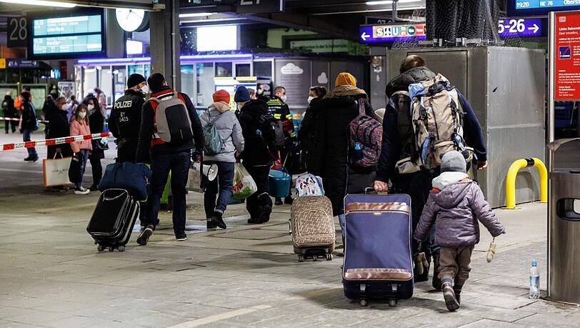 Zahlreiche Flüchtlinge aus der Ukraine gehen nach ihrer Ankunft aus der Ukraine zur Registrierung am Münchner Hauptbahnhof.