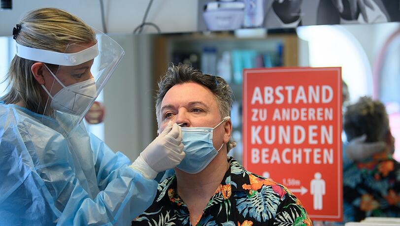 Ein Friseurmeister bekommt einen Schnelltest - auch Kunden brauchen den in Bayern. Ein Friseurmeister bekommt einen Schnelltest - auch Kunden brauchen den in Bayern.