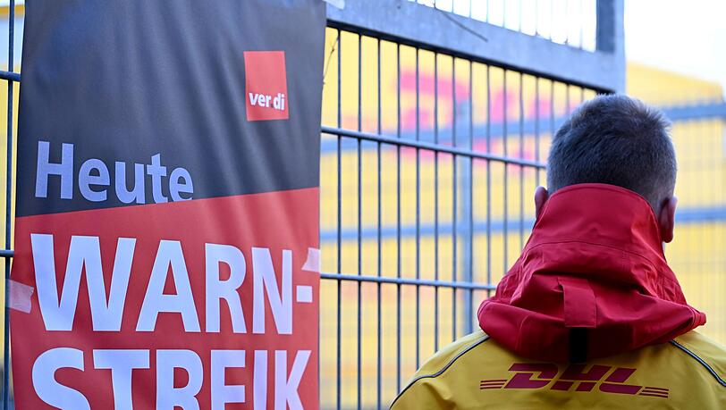 Ein warnstreikender DHL-Mitarbeiter an einem Standort der Post, die zu DHL gehört. Ein warnstreikender DHL-Mitarbeiter an einem Standort der Post, die zu DHL gehört.