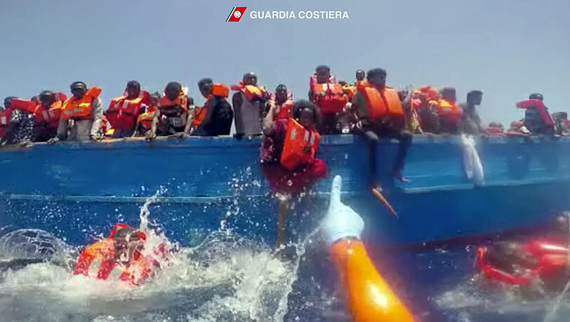 Die Szene aus einem Video der italienischen Küstenwache zeigt die Rettung von Flüchtlingen im Mittelmeer Die Szene aus einem Video der italienischen Küstenwache zeigt die Rettung von Flüchtlingen im Mittelmeer