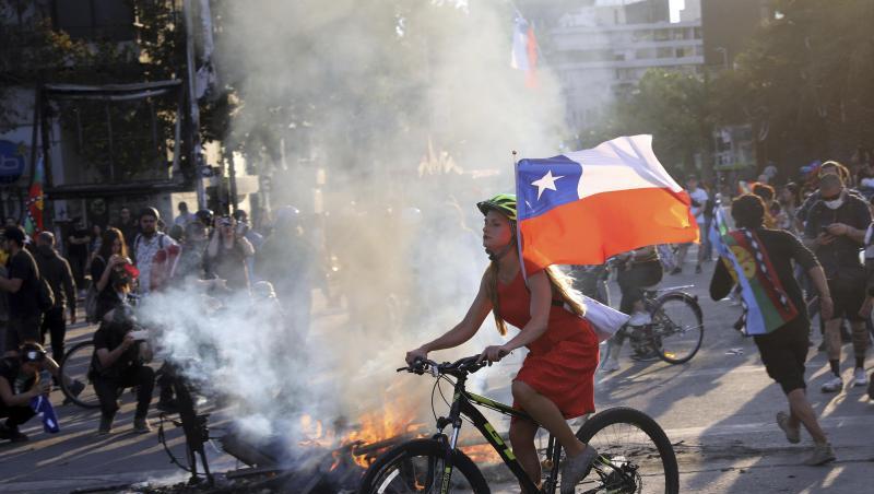 Bei einer Protestaktion gegen die Regierung hat eine junge Frau in Santiago ihr Fahrrad mit der chilenischen Flagge ausgestattet. Bei einer Protestaktion gegen die Regierung hat eine junge Frau in Santiago ihr Fahrrad mit der chilenischen Flagge ausgestattet.