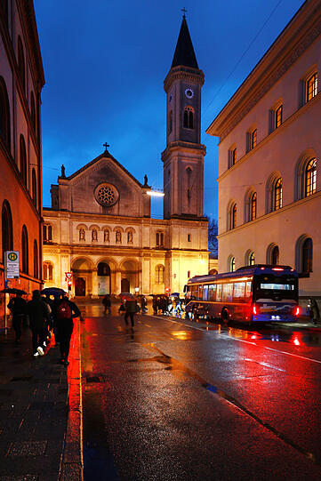 Blaue Stunde mit rotem Rücklicht und hell angestrahlter Ludwigskirche.
