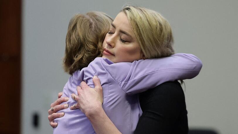 Amber Heard umarmt nach der Verkündung des Urteils ihre Anwältin. Amber Heard umarmt nach der Verkündung des Urteils ihre Anwältin.