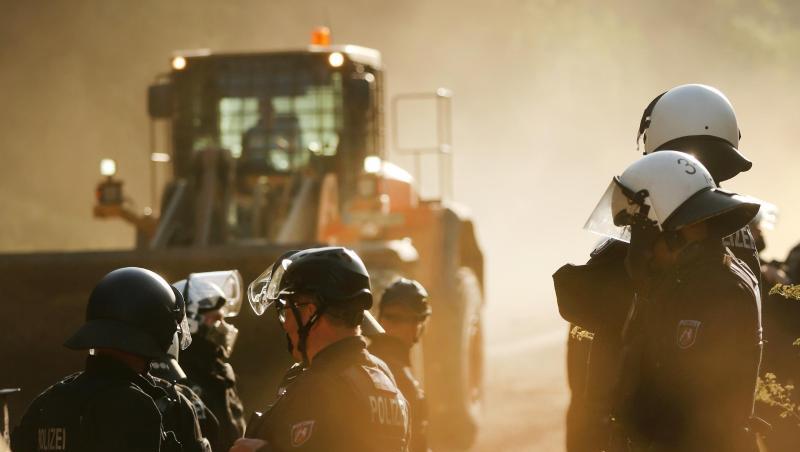Polizisten stehen im Hambacher Forst neben einer Planierraupe. Polizisten stehen im Hambacher Forst neben einer Planierraupe.