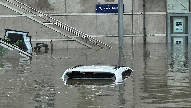 Ein Auto steht in einer überschwemmten Unterführung. Ein Auto steht in einer überschwemmten Unterführung.
