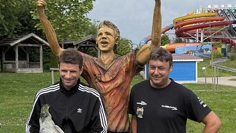 Fußballprofi Müller (l.) freut sich über die Holzskulptur, die Wastian in Handarbeit geschaffen hat. Fußballprofi Müller (l.) freut sich über die Holzskulptur, die Wastian in Handarbeit geschaffen hat.