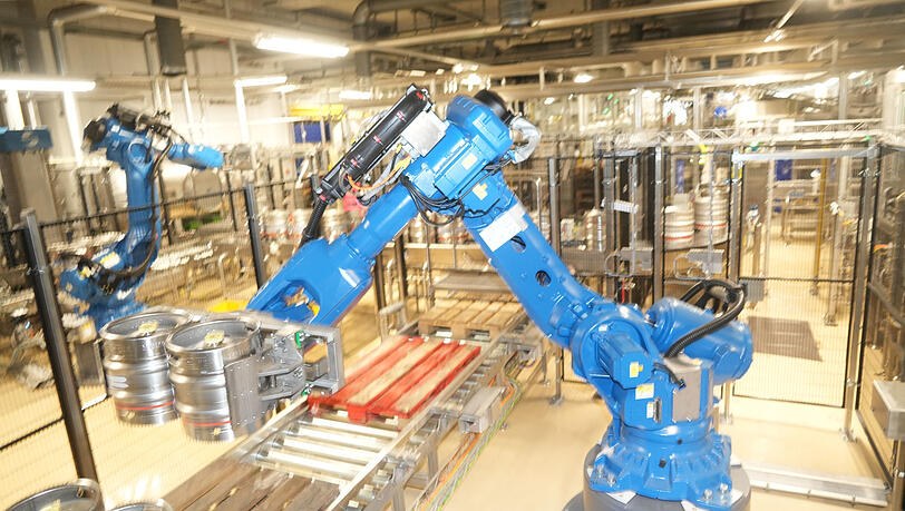 Der Roboter verlädt die Fässer am Ende auf die Paletten. Der Roboter verlädt die Fässer am Ende auf die Paletten.