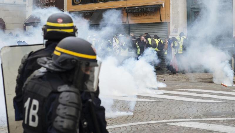 Polizisten feuern mit Tränengas auf "Gelbwesten"-Demonstranten nahe der Kirche "La Madeleine" in Paris. Erneut sind in Frankreich zahlreiche Menschen auf die Straße gegangen. Polizisten feuern mit Tränengas auf "Gelbwesten"-Demonstranten nahe der Kirche "La Madeleine" in Paris. Erneut sind in Frankreich zahlreiche Menschen auf die Straße gegangen.
